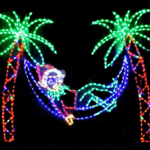 Santa in hammock between lit palm trees